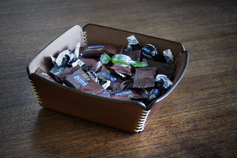 Vaciabolsillos de cuero lleno de caramelos